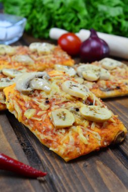 Siyah zemin üzerinde taze pizza ve malzemeler.