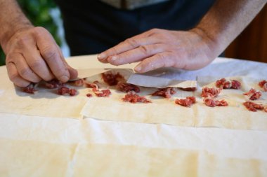 Adam etli börek hazırlıyor. 