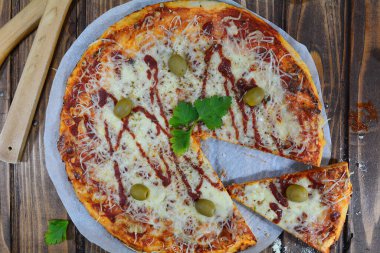 Siyah zemin üzerinde taze pizza ve malzemeler.