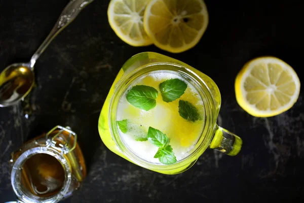 fresh lemonade with lemon and mint on black background