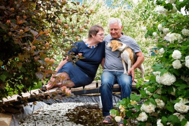 Yaşlı çift, yetişkin erkek ve kadın dışarıda, köpek evcil hayvanıyla.