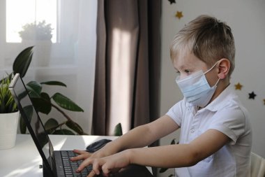 Uzaktan öğrenme online eğitim, çocuk dizüstü bilgisayarla ödev yapıyor