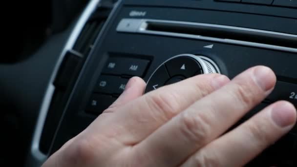 Male hand adjusts the tuning of the car radio, hands close up — Stock Video