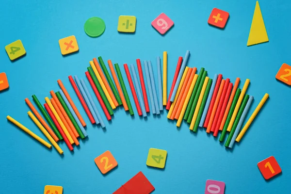 Schulhintergrund - Zahlen, Zählstäbe, geometrische Figuren auf blauem Hintergrund — Stockfoto