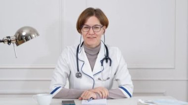 Kadın tıp asistanı videosu laptoptan uzak bir hastayı arıyor. Doktor sanal sohbet bilgisayar uygulaması kullanarak istemciyle konuşuyor.