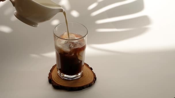 Hideg jeges kávé tejszínhabbal fehér alapon. — Stock videók