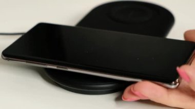 Siyah smartphone bir kablosuz şarj istasyonu şarj. Kablosuz teknoloji kavramı.