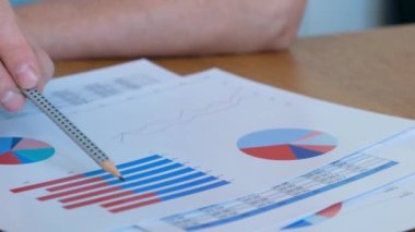 Ofiste iş diyagramıyla çalışan adam, kapat.