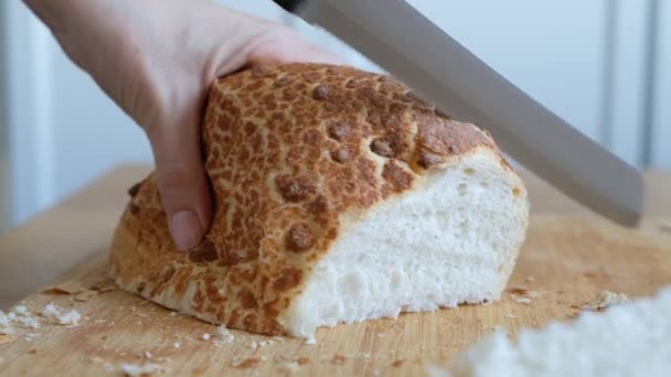 Ktoś kroi świeżo upieczony miękki chleb, z bliska — Wideo stockowe