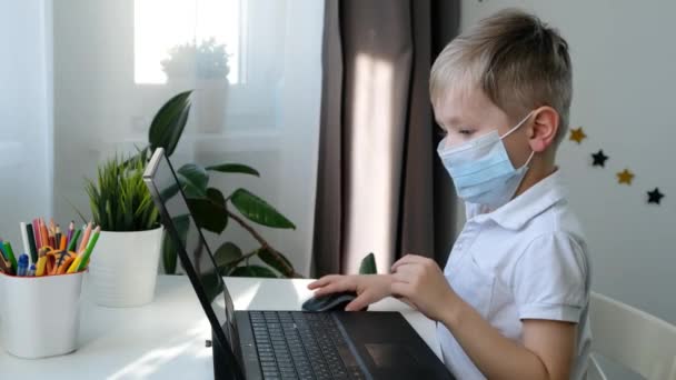 Милий маленький дошкільний хлопчик у навчанні медичної маски на комп'ютері, концепція дистанційної освіти — стокове відео