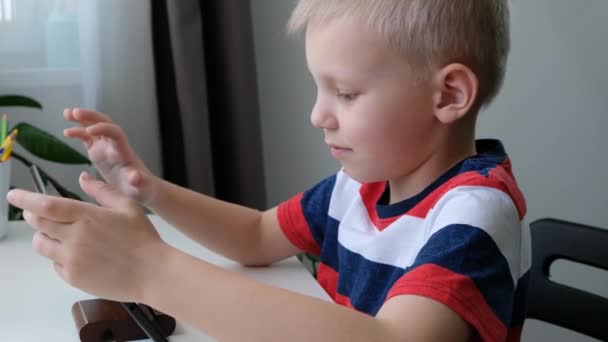 Милий школяр, який навчається або грає на планшетному ПК, концепція дистанційної освіти . — стокове відео