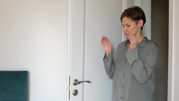 Грустная женщина в пижаме страдает от головной боли, депрессии, кризиса среднего возраста — стоковое видео