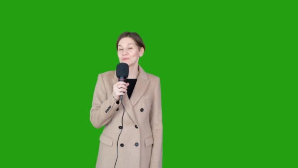 グリーンスクリーンクロマKey 30代半ば白人女性テレビの報道記者は 緑の背景に対して正式な服装で話しています 風の強い曇りの日に外で — ストック動画