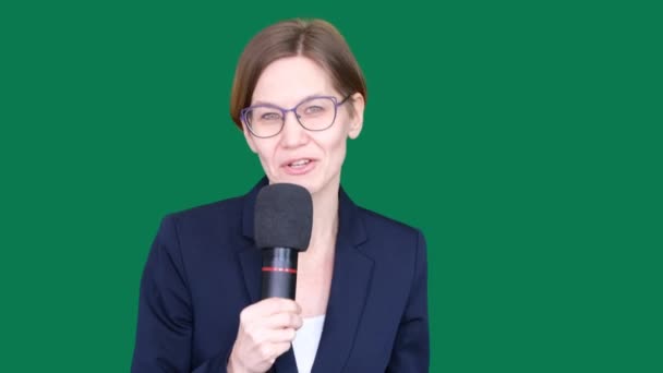 Donna reporter in giacca e cravatta guarda nella fotocamera e parla in microfono, femmina su sfondo verde, modello per agenzie di stampa TV, giornalista al lavoro, chromakey. — Video Stock