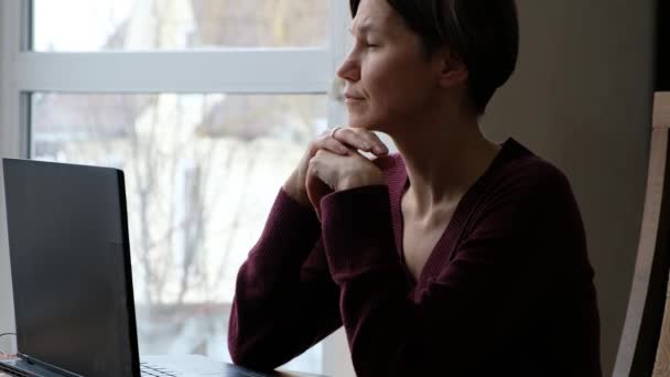 Verontruste vrouw die naar het raam kijkt. close-up van verdrietig denken zakenvrouw met laptop denken over fouten in het werk, verloren baan, depressie, middelbare leeftijd crisis. — Stockvideo