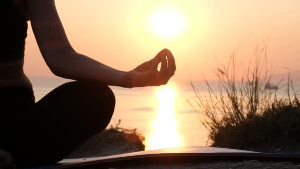 Donna non riconosciuta che fa meditazione yoga alla luce del tramonto sulla riva del mare, Silhouette da vicino — Video Stock