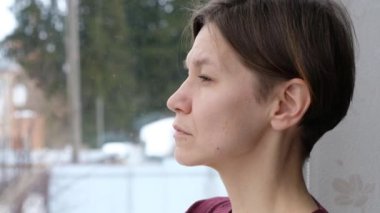 Depresyondaki genç bir kadın sorun için üzülüyor. Üzgün kızın yansıması, pencereden bakıp zihinsel stres kavramını düşünmesi. Yan yüzünü kapat.