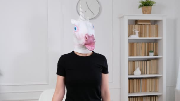 Mujer en cabeza de unicornio mostrando brazos fuertes deportivos - divertido video extraño — Vídeos de Stock