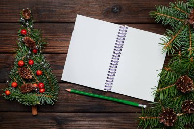 Firavun dalları Noel ağacı şeklinde ve tahta bir arka planda boş bir not defteri.