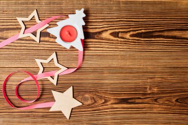 Noel ağacı, mum, yıldızlar ve ahşap zemin üzerinde fotokopi alanı olan pembe kurdeleli Noel Flatlay 'i