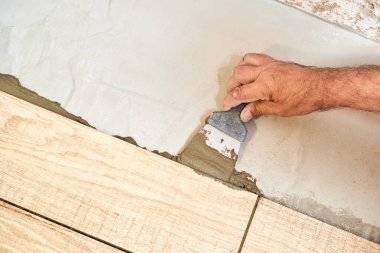 Seramik döşeme döşeyen adam. Yakın çekim, seçici odaklanma