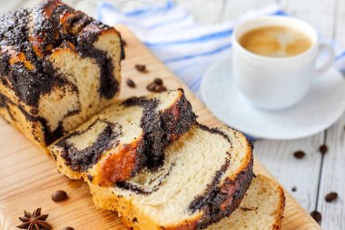 Ahşap arka planda bir fincan kahveyle ev yapımı haşhaşlı çörek. Yakın çekim, seçici odaklanma