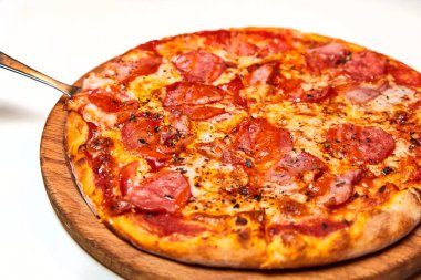 Salamlı pizza, dolmalık biber, domates ve peynir, turşu, pastırma ve sosis. Yakın çekim, seçici odaklanma