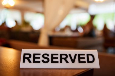 Restoran masasında yazılı plastik plaket var.