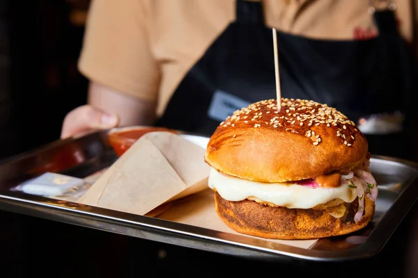 Kelner Trzyma Hamburgera Wołowiną Serem Zbliżenie Selektywne Ukierunkowanie — Zdjęcie stockowe