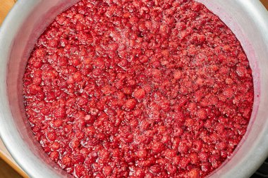 Ev yapımı ahududu reçeli yapmak alüminyum kasede bütün böğürtlenlerle. Yakın çekim, seçici odaklanma