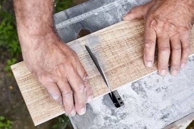 Bir adam seramik bir fayansı serinletilmiş suyla keser. Yakın çekim, seçici odaklanma
