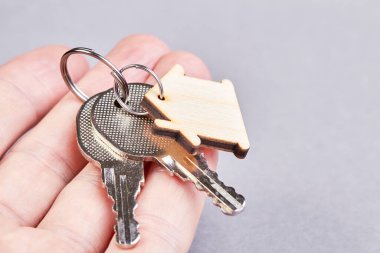 Yeni dairenin anahtarları arka planda oturan bir adamın elinde.