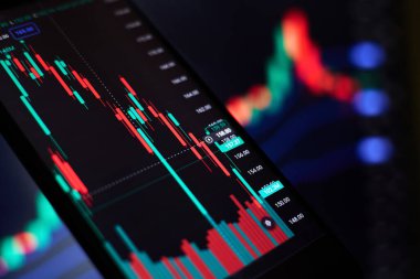 Akıllı telefondaki borsa grafiği ve ses göstergesi ekrandaki bulanık grafiklerin arka planına karşı