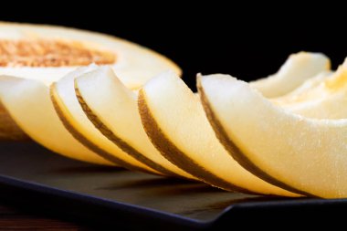 Karpuz dilimleri ve ahşap bir tahtanın üzerinde kavun parçaları.