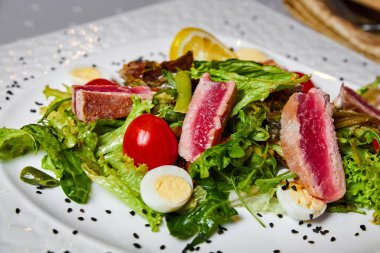 Orta pişmiş ton balığı, karışık salata ve bıldırcın yumurtası.