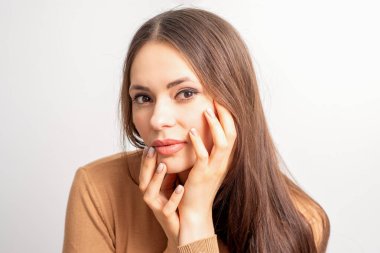 Beyaz arka planda izole edilmiş manikürlü parmakları olan beyaz kadın modelin portresi.