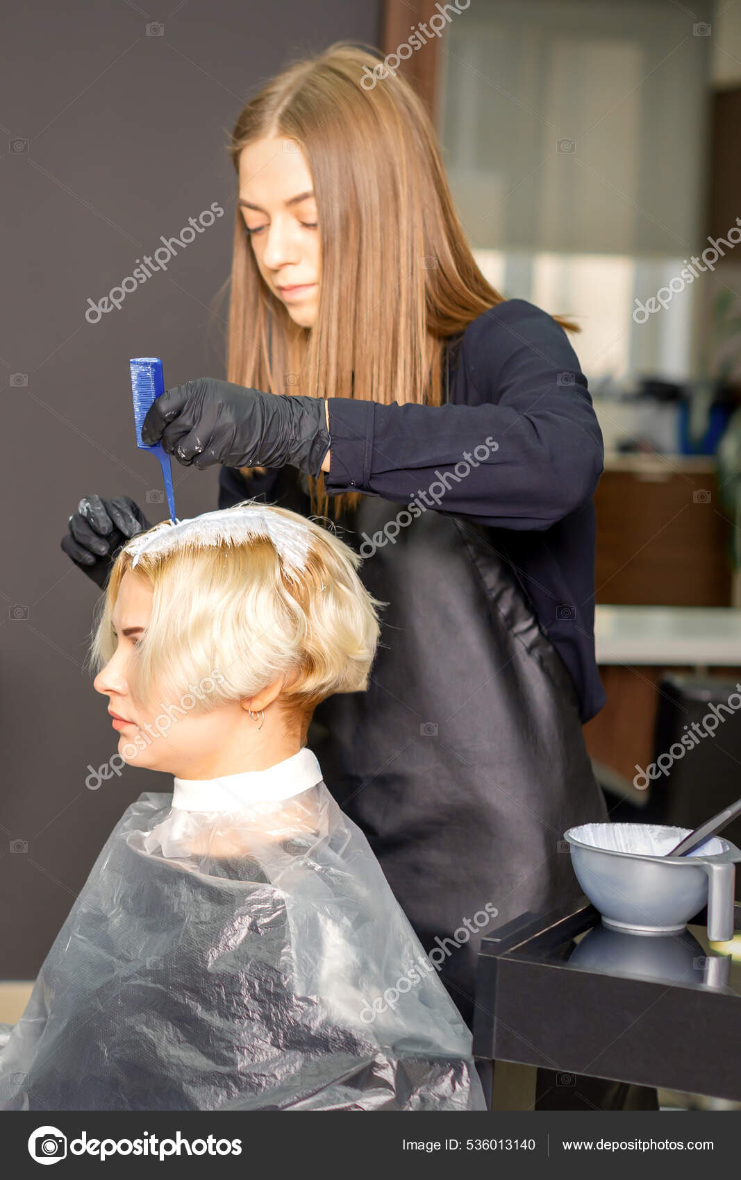 Cabeleireiro profissional fica em um salão de beleza com um