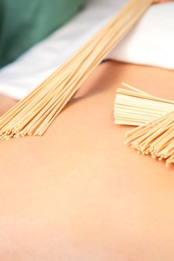 Genç bir kadın, spa 'da bambu süpürgelerle çifte samuray masajı yaptırıyor. Rahatlama masaj konsepti