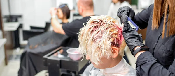 专业的理发师用刷子把粉色染料涂在头发上 染发概念 — 图库照片
