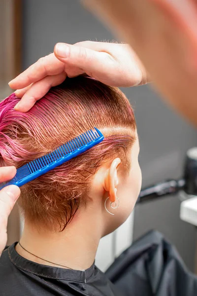 ヘアサロンでピンク色の髪を着色中の若い女性の髪を閉じる — ストック写真