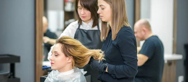 Twee Vrouwelijke Haarstylisten Bereiden Lang Haar Van Een Jonge Vrouw — Stockfoto