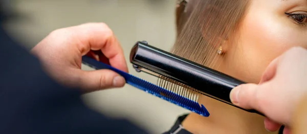 Fryzjer Prostuje Włosy Młodej Brunetki Salonie Piękności — Zdjęcie stockowe