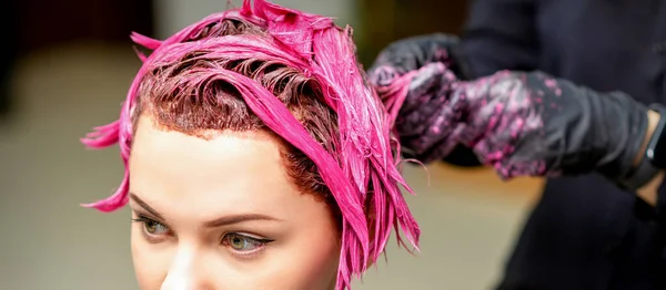 专业的理发师用刷子把粉色染料涂在头发上 染发概念 — 图库照片