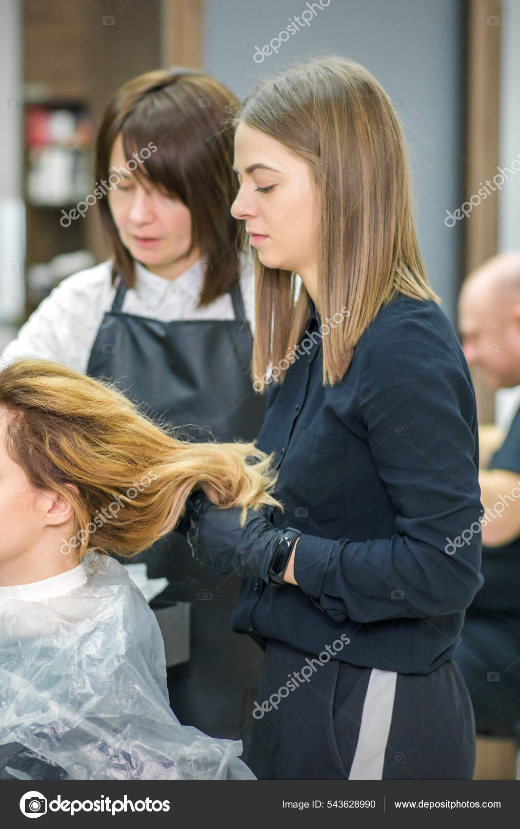Cabeleireiro seca o cabelo com secador de cabelo para uma mulher