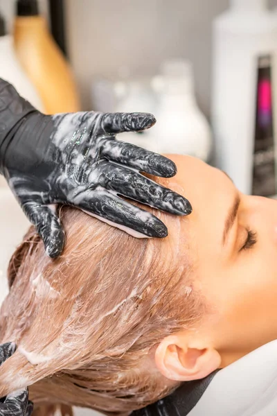 年轻的高加索金发女人在美容院洗头 — 图库照片