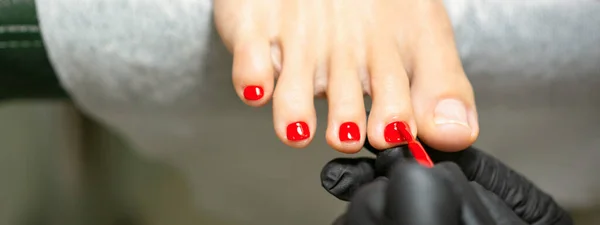 Pedicurist Trägt Einem Schönheitssalon Roten Nagellack Auf Die Weiblichen Fußnägel — Stockfoto