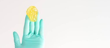 Sarı şeker yapıştırıcısı tüy dökücü ustasında. Gülümseyen güzellik uzmanı beyaz arka planda tüy dökmek için balmumu tutuyor. Epilasyon kavramı