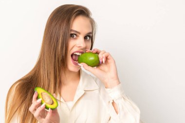 Diyet beslenme. Beyaz arka planda organik yeşil avokado yiyen güzel beyaz kadın. Sağlıklı yaşam tarzı, sağlık konsepti