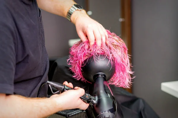 ヘアスタイル美容室でぬれたカスタムピンクの髪に吹いてヘアドライヤーを使用してヘアドライヤーを作る — ストック写真