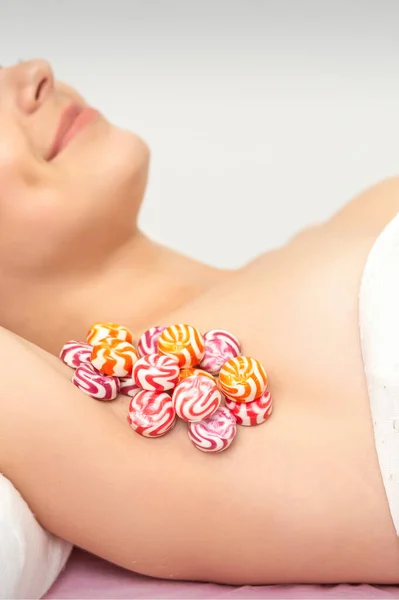 Colored round candies under the female armpit, close up, depilation armpit concept